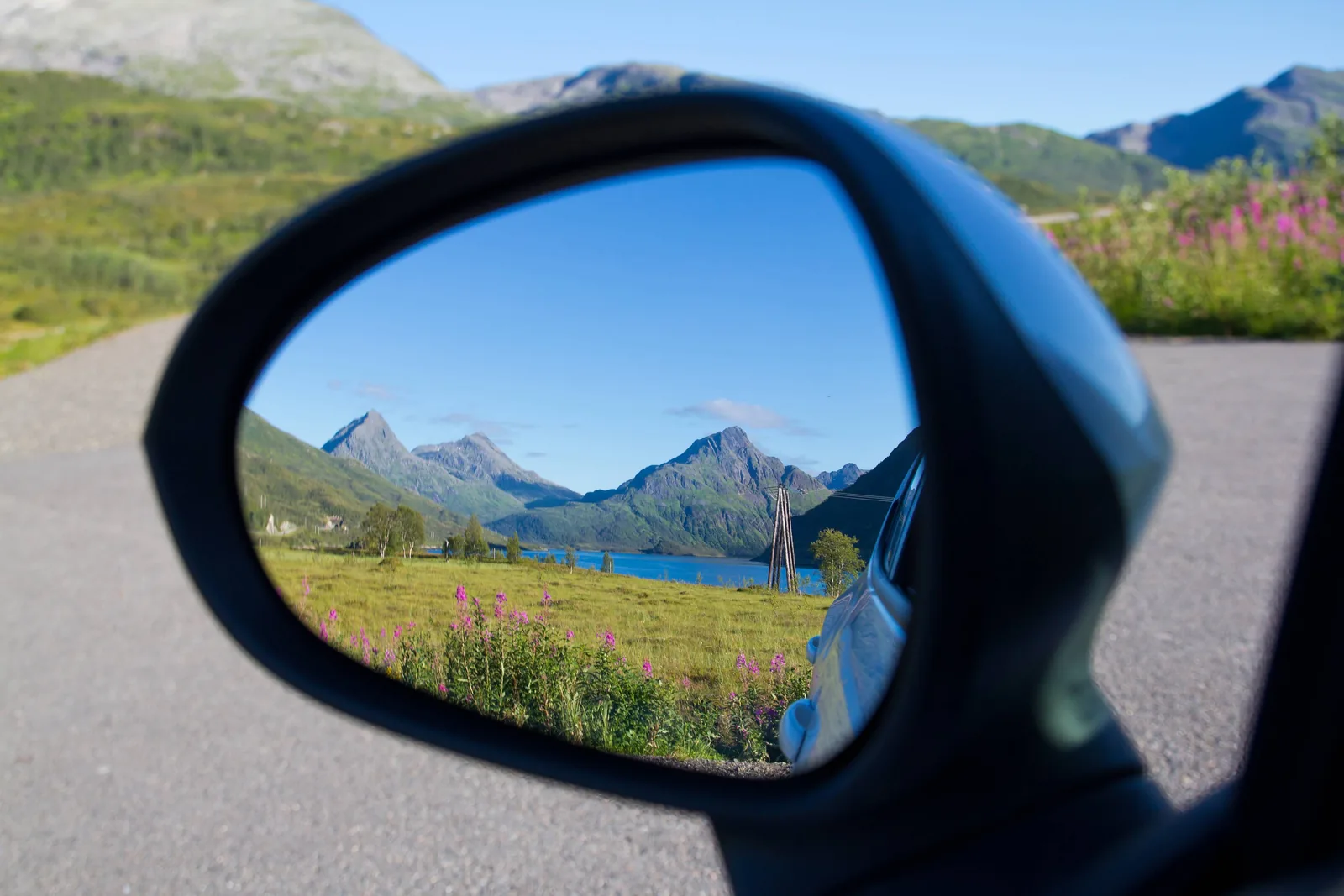Fjellandskap og vei sett gjennom et sidespeil