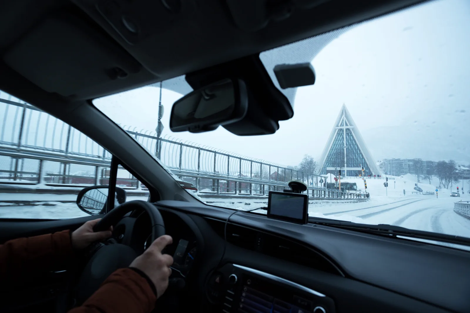 Bilfører på vintervei med navigasjon i frontruten
